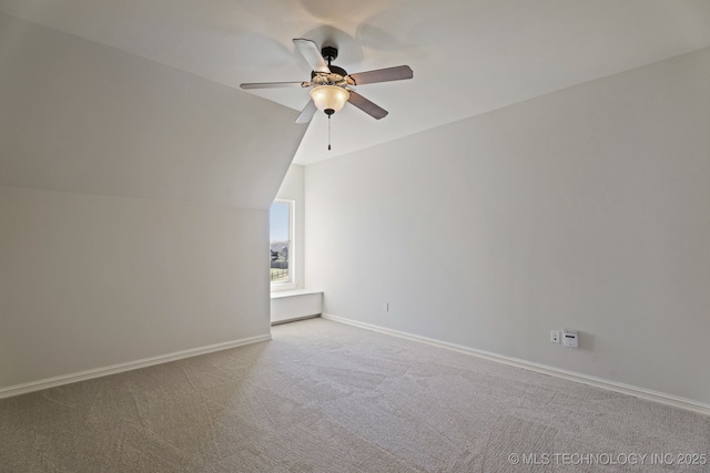 spare room with carpet floors, baseboards, ceiling fan, and vaulted ceiling