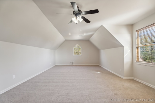 bonus room with baseboards, ceiling fan, lofted ceiling, and light carpet