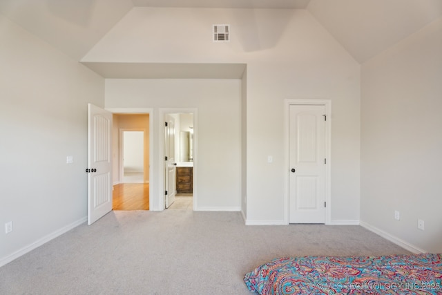 unfurnished bedroom featuring connected bathroom, carpet floors, high vaulted ceiling, baseboards, and visible vents