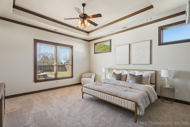 bedroom featuring visible vents, ornamental molding, a tray ceiling, and light carpet