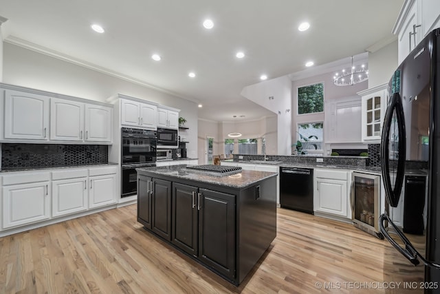 kitchen featuring crown molding, white cabinetry, wine cooler, and black appliances