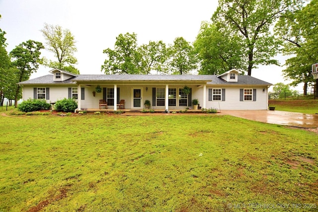 rear view of property featuring a porch, a yard, and concrete driveway