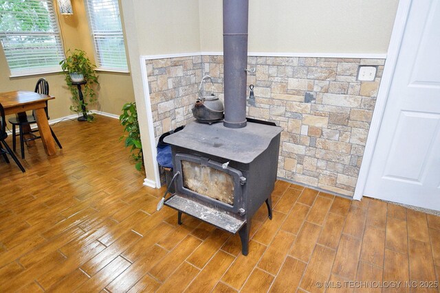 details with a wood stove and wood finished floors