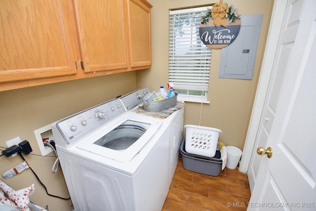 laundry area featuring cabinet space, wood tiled floor, washing machine and clothes dryer, and electric panel