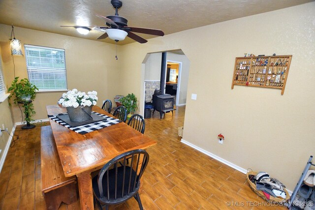 26204 S 532nd Rd, Park Hill, OK 74451 - dining space featuring baseboards, a ceiling fan, arched walkways, a wood stove, and wood finished floors