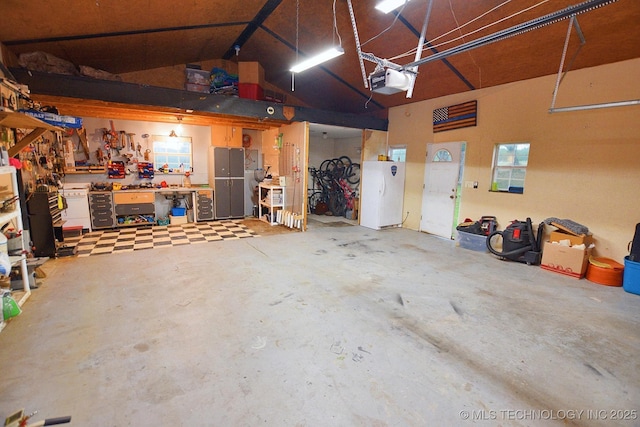 26204 S 532nd Rd, Park Hill, OK 74451 - garage featuring a workshop area, a garage door opener, and freestanding refrigerator