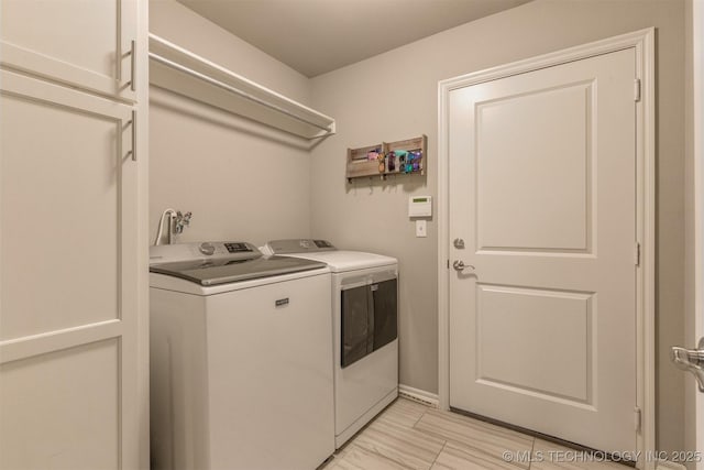 clothes washing area featuring separate washer and dryer and laundry area