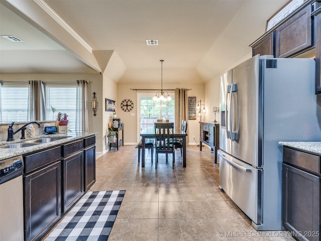 kitchen with light tile patterned flooring, a sink, a chandelier, stainless steel appliances, and visible vents
