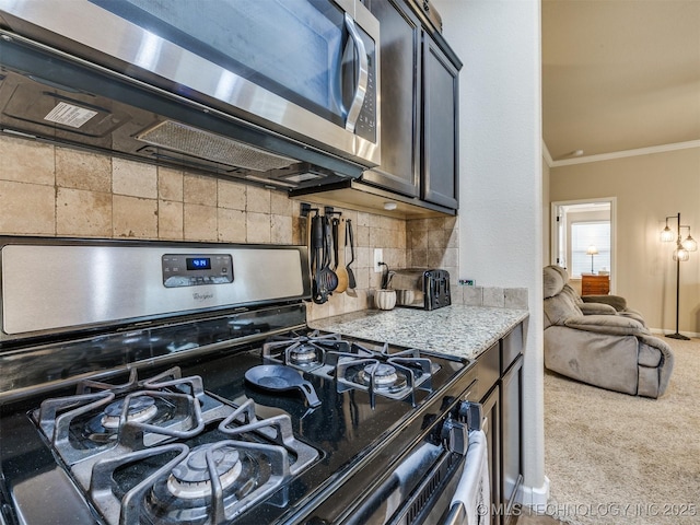 kitchen featuring crown molding, carpet flooring, light stone countertops, stainless steel appliances, and backsplash