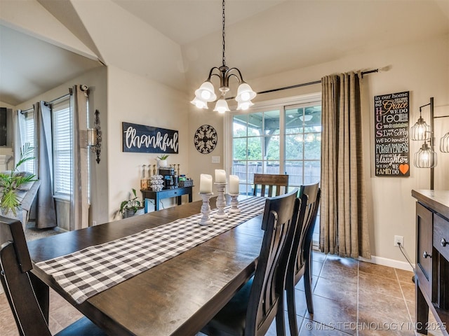 dining area featuring baseboards, lofted ceiling, and a chandelier
