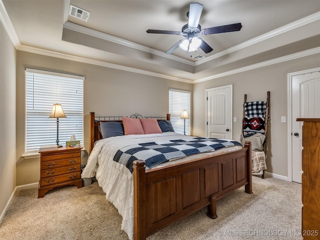 bedroom with light carpet, a tray ceiling, and visible vents