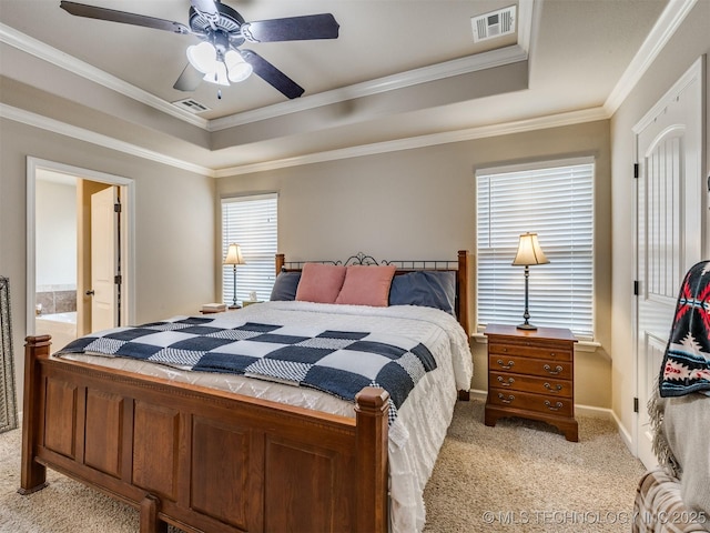bedroom featuring a tray ceiling, visible vents, light carpet, and ornamental molding