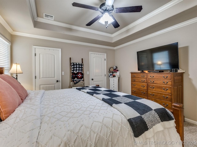 bedroom with carpet flooring, a tray ceiling, visible vents, and crown molding