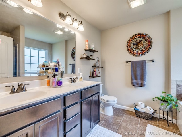 full bathroom with a sink, baseboards, toilet, and double vanity