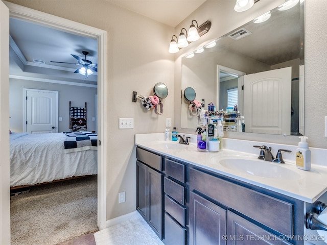 ensuite bathroom with connected bathroom, ceiling fan, visible vents, and a sink