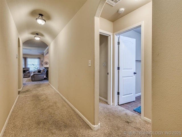 corridor with arched walkways, carpet, and visible vents
