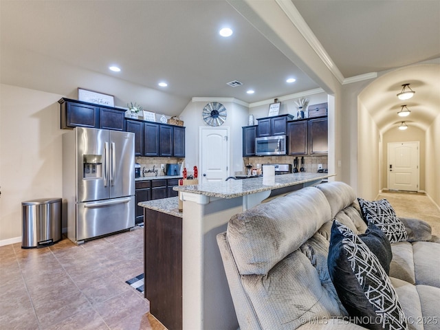 kitchen with crown molding, decorative backsplash, visible vents, and stainless steel appliances