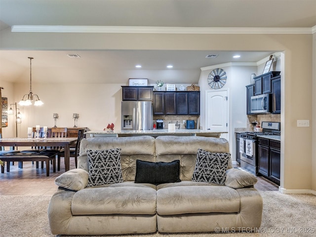 living room with recessed lighting, ornamental molding, a chandelier, and light colored carpet
