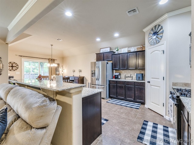 kitchen featuring stainless steel fridge with ice dispenser, a breakfast bar, recessed lighting, tasteful backsplash, and range with gas cooktop