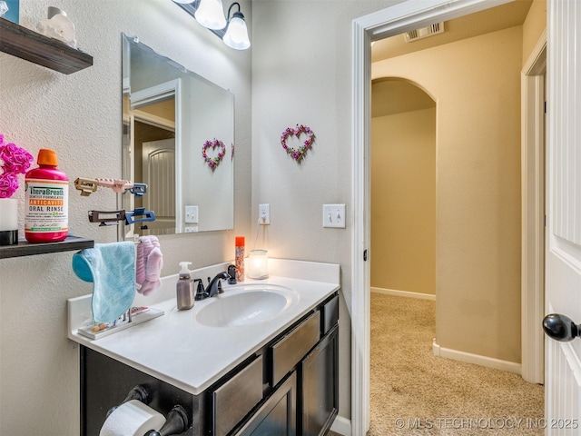 bathroom with visible vents, baseboards, and vanity