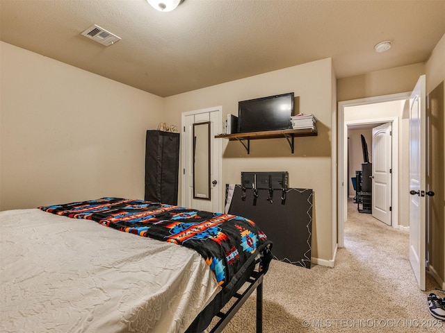 bedroom with visible vents, baseboards, and light carpet