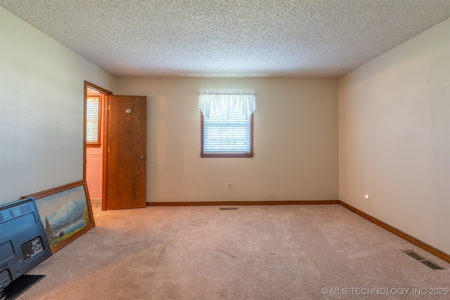 2305 S Hickory Pl, Broken Arrow, OK 74012 - spare room featuring healthy amount of natural light, a textured ceiling, carpet flooring, and baseboards