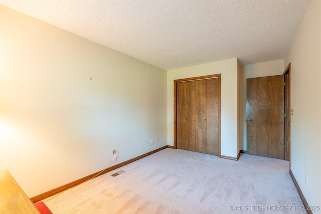 2305 S Hickory Pl, Broken Arrow, OK 74012 - unfurnished bedroom featuring light carpet, a closet, a textured ceiling, and baseboards