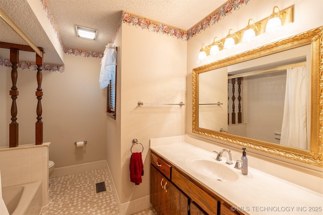 2305 S Hickory Pl, Broken Arrow, OK 74012 - bathroom with a textured ceiling, toilet, vanity, baseboards, and a bath