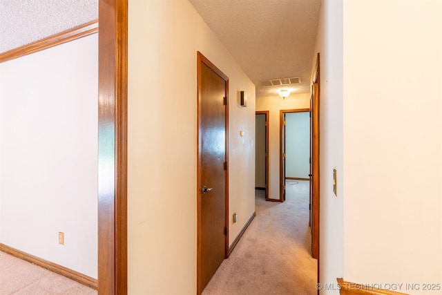 2305 S Hickory Pl, Broken Arrow, OK 74012 - hallway featuring light carpet, a textured ceiling, and baseboards