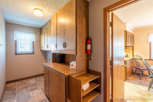 2305 S Hickory Pl, Broken Arrow, OK 74012 - washroom featuring a textured ceiling, stone finish floors, and baseboards