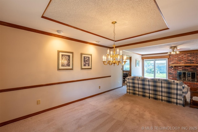 2305 S Hickory Pl, Broken Arrow, OK 74012 - living room featuring a tray ceiling, carpet, a textured ceiling, a chandelier, and ornamental molding