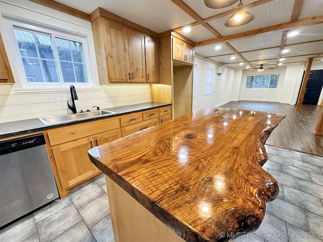 kitchen featuring stainless steel dishwasher, a kitchen island, wooden counters, beamed ceiling, and a sink