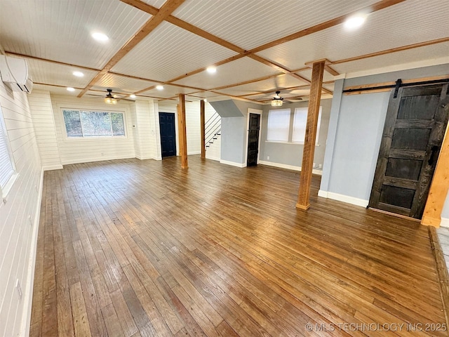 unfurnished living room featuring ceiling fan, a barn door, stairway, wood-type flooring, and recessed lighting