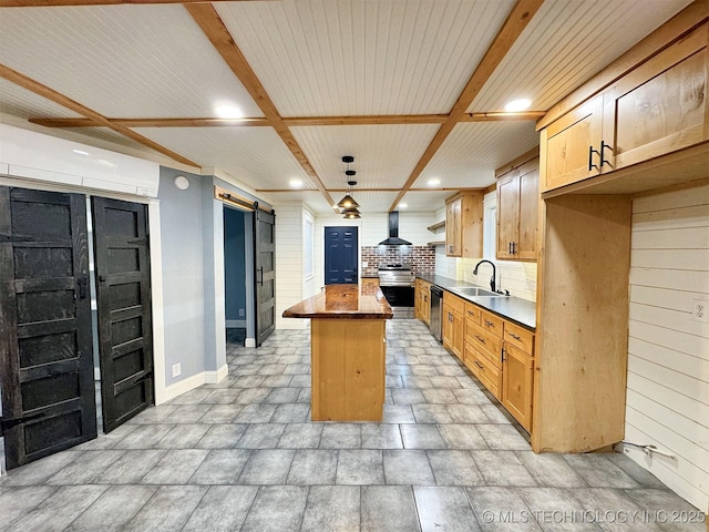 kitchen with a barn door, dishwasher, a sink, baseboards, and wall chimney exhaust hood