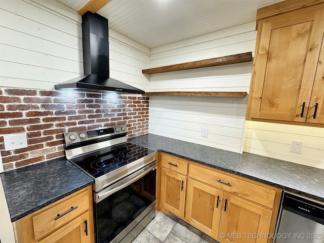 kitchen with wall chimney range hood, open shelves, appliances with stainless steel finishes, wood walls, and dark stone countertops