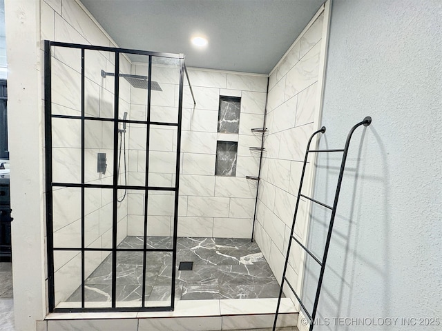 full bathroom with a textured wall and a stall shower