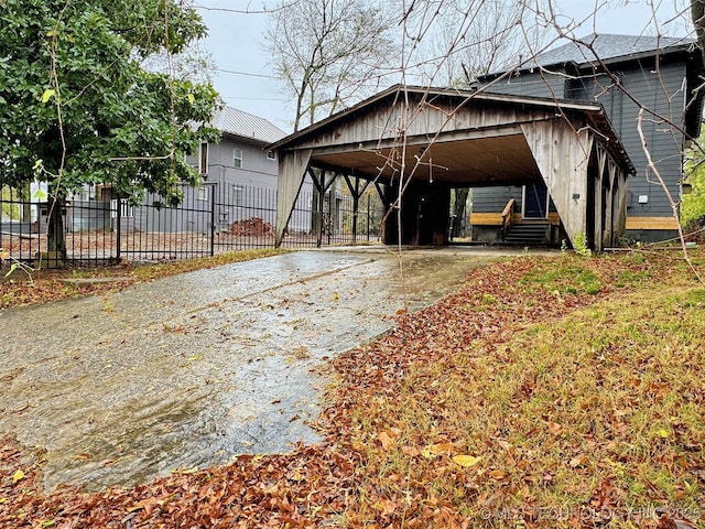 exterior space with fence, driveway, and a detached carport