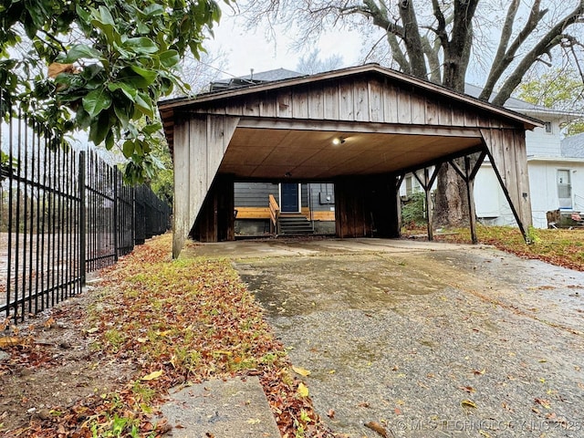 exterior space with fence, driveway, and a carport