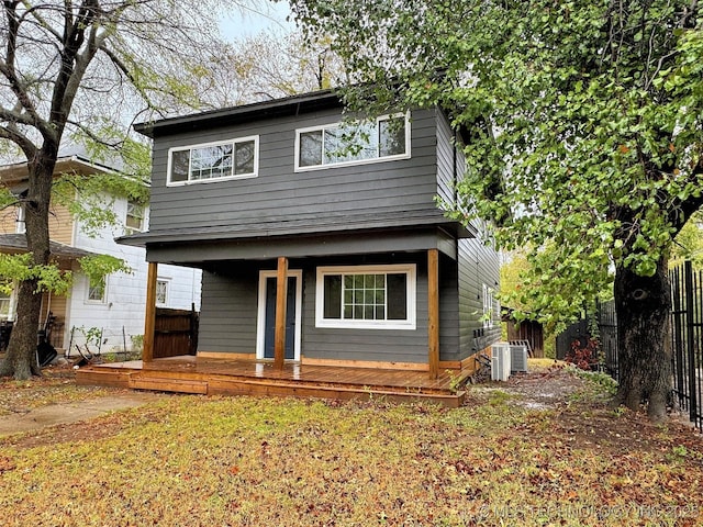 view of front of property featuring a porch, fence, and cooling unit