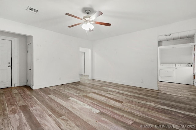 unfurnished room featuring visible vents, ceiling fan, wood finished floors, and washer and dryer