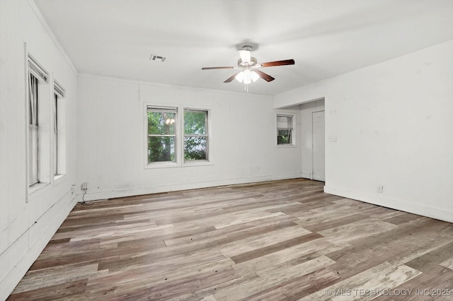 unfurnished bedroom featuring baseboards, ceiling fan, wood finished floors, and visible vents