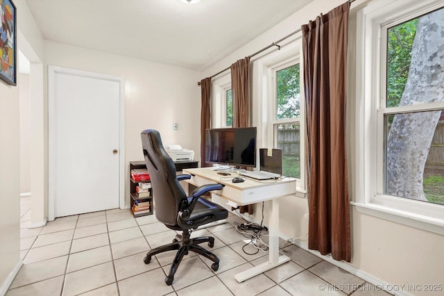 office space with light tile patterned floors, baseboards, and a wealth of natural light
