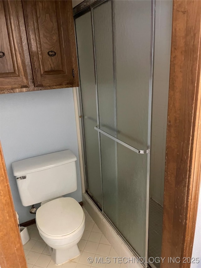 full bathroom with tile patterned flooring, toilet, and a shower stall