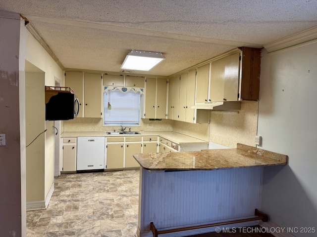 kitchen featuring stone finish flooring, white dishwasher, a sink, a peninsula, and ornamental molding