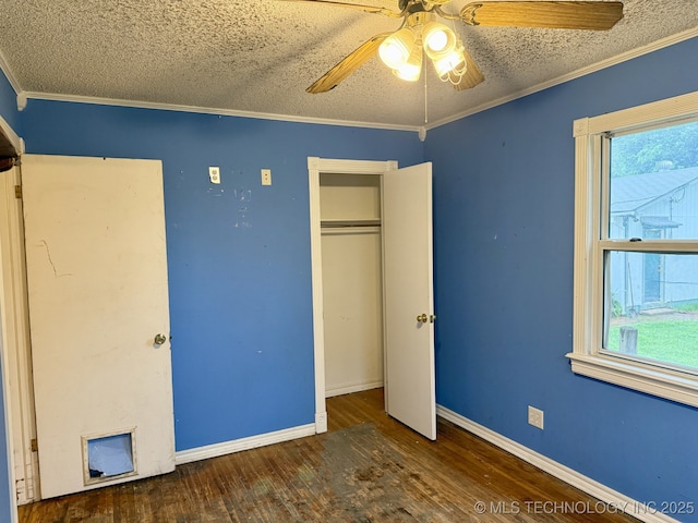 unfurnished bedroom with a textured ceiling, multiple windows, and hardwood / wood-style floors