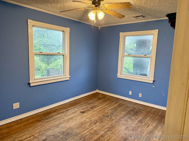empty room featuring visible vents, wood finished floors, baseboards, ceiling fan, and a textured ceiling
