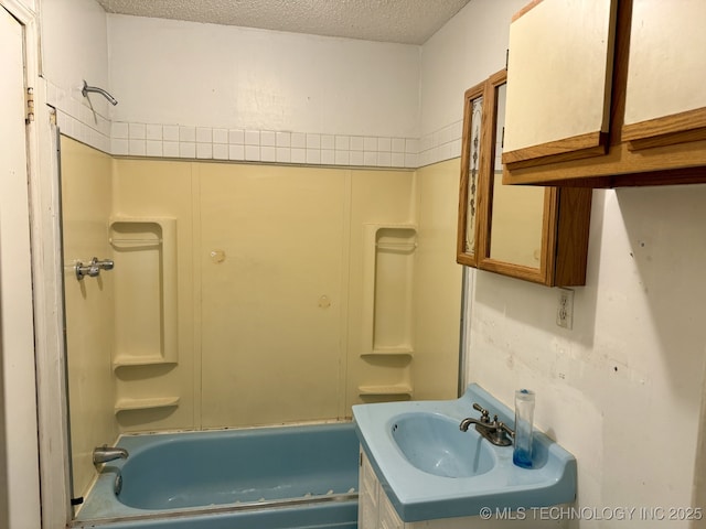 bathroom with shower / bathtub combination, a textured ceiling, and vanity