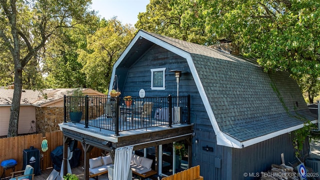 24591 S 613th Rd, Grove, OK 74344 - exterior space featuring a chimney, a wooden deck, fence, a gambrel roof, and a shingled roof
