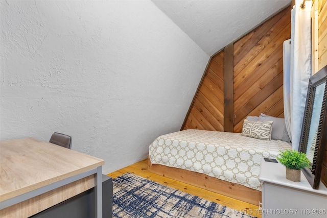 24591 S 613th Rd, Grove, OK 74344 - bedroom with wooden walls, a textured wall, wood finished floors, and lofted ceiling