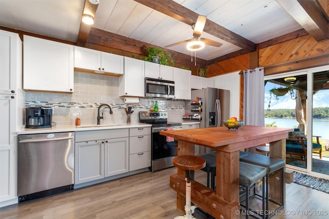 24591 S 613th Rd, Grove, OK 74344 - kitchen featuring backsplash, a sink, beamed ceiling, light wood finished floors, and stainless steel appliances